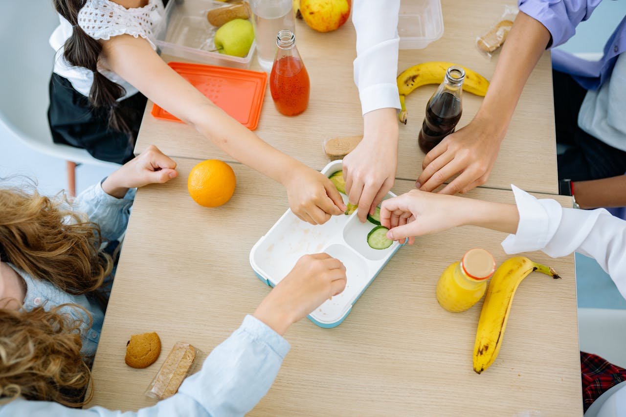 gallery-1 Children enjoying a variety of healthy snacks and drinks at a shared table, top view.